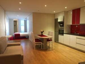 a kitchen and living room with a table and a couch at ÍSIS Guest House in Braga
