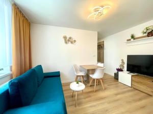 Mand apartmán في زيلينا: غرفة معيشة مع أريكة زرقاء وطاولة