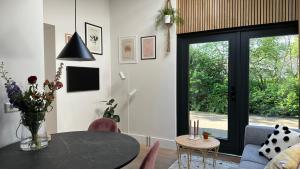 a living room with a table and a glass door at bedandbreakfastrouveen in Rouveen
