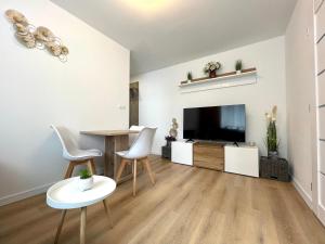 a living room with a dining table and a tv at Mand apartmán in Žilina