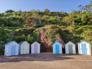 a row of colourful beach huts in a parking lot at Cleve Court Hotel in Paignton