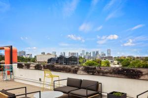 a balcony with chairs and a view of a city at Placemakr Wedgewood-Houston in Nashville