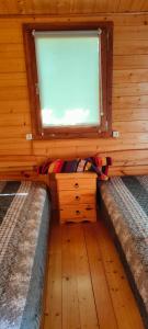 a small room with a window and a wooden wall at Domek letniskowy u Bodzia in Kruklanki