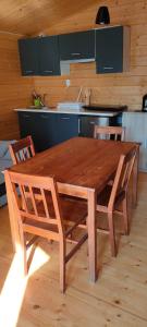 a wooden table and chairs in a kitchen at Domek letniskowy u Bodzia in Kruklanki