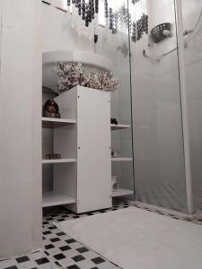 La salle de bains blanche est pourvue d'un lavabo et d'une douche. dans l'établissement Studio Leblon, à Rio de Janeiro