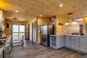 a kitchen with a refrigerator and wooden walls at Teddy Bear Cabin in Sevierville