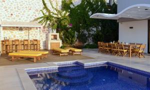 a patio with a table and chairs and a pool at villa ozma in Kaş