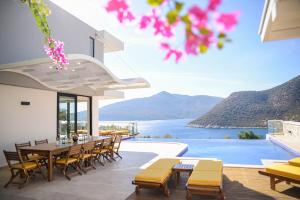 a patio with a table and chairs and a view of the water at villa ozma in Kaş
