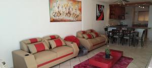 a living room with two couches and a dining room at A Beach Condo in Durban