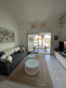 ein Wohnzimmer mit einem Sofa und einem Tisch in der Unterkunft Appartement avec piscine in Grimaud