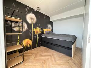 a bedroom with a bed and dandelions on the wall at Apartment directly to seafront of Bassin 7 with big balcony and free parking in Aarhus