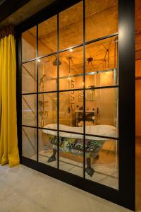 Cette chambre dispose d'une grande fenêtre en verre et d'une baignoire. dans l'établissement Arthouse New York, à Liepāja