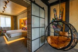 une pièce avec une chaise suspendue en rotin et une chambre dans l'établissement Arthouse New York, à Liepāja