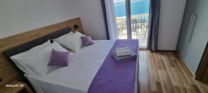 sypialnia z łóżkiem z fioletowymi i białymi poduszkami w obiekcie Apartment Petra w mieście Starigrad-Paklenica +37 zdjęć