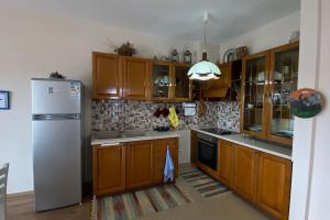 a kitchen with wooden cabinets and a refrigerator at Belvedere Centro Shkoder in Shkodër +14 photos