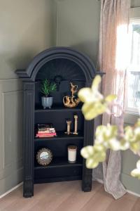 una estantería de libros negros en una habitación con ventana en Pioneer Heritage Apt 2 Downtown Rridgefield, en Ridgefield