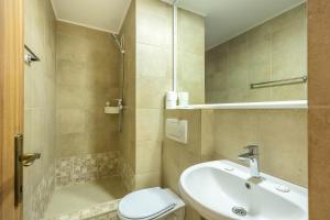 a bathroom with a sink and a toilet and a shower at Hotel Venus in Mamaia +57 photos