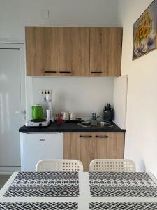a kitchen with a sink and a table and chairs at ApHEARTments in Gevgelija +7 photos