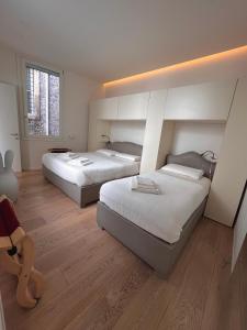 two beds in a large room with wooden floors at B&B Casa Diaz in Verona