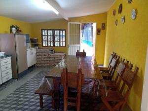 a kitchen with a large wooden table and chairs at Sitio Oliveira Ibiuna in Ibiúna