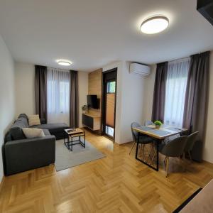 ein Wohnzimmer mit Sofa und Tisch in der Unterkunft PIK Apartmani in Vrnjačka Banja