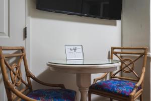 a table with two chairs and a tv on a wall at Harbour House at the Inn 316 in Fort Myers Beach