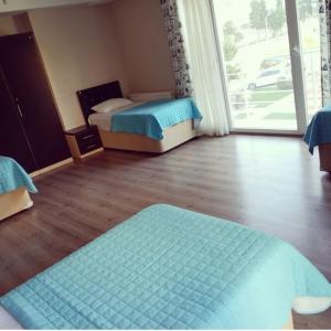 a bedroom with two beds and a large window at Elit Yurt&Aile Pansyonu in Samsun