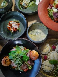 a table with plates of food and bowls of food at Prawdzic Family Resort & Wellness in Gdańsk