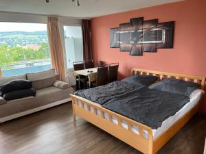 a bedroom with a bed and a couch and a table at schönes Apartment mit Festungsblick - FREE Parking - in Würzburg