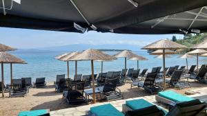 a group of chairs and umbrellas on a beach at Mitzela Mare House in Amaliapoli