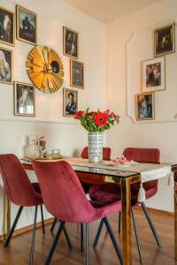 a dining room table with red chairs and a vase with flowers at HOLT - Gryffindor Tower in Bucharest