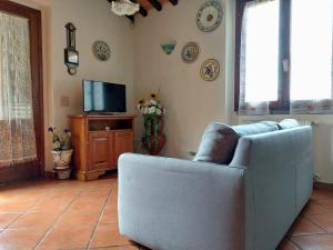 sala de estar con sofá y TV en Casa Vacanze - La Ginestra, en Ginestra