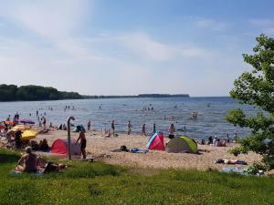 a group of people on a beach with tents at Ostsee 1 in Zierow