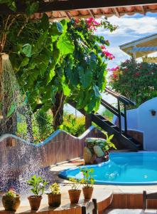 a swimming pool in a garden with potted plants at Pousada Sahara in Jericoacoara