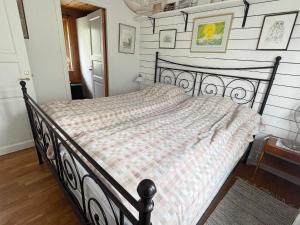 - une chambre avec un lit noir et une couverture en damier dans l'établissement Holiday home Torhamn II, à Torhamn