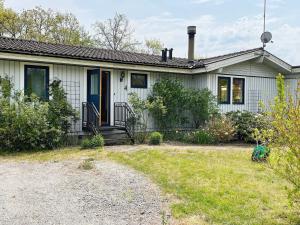 une maison blanche avec une porte bleue et une cour dans l'établissement Holiday home Torhamn II, à Torhamn