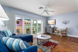 a living room with a blue couch and a table at Harbour House at the Inn 207 in Fort Myers Beach