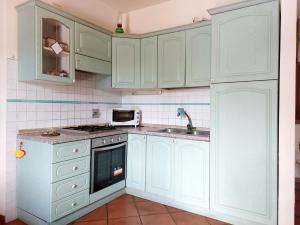 Kuchnia wyposażona jest w zielone szafki, umywalkę i kuchenkę mikrofalową. w obiekcie Casa Vacanze - La Ginestra w mieście Ginestra
