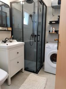 a bathroom with a shower and a washing machine at Apartment Bistrica Sunce in Sutivan