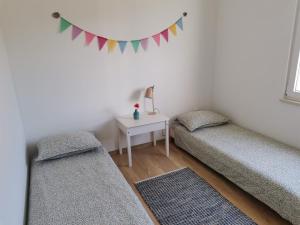 a room with two beds and a table with a flag at Apartment Bistrica Sunce in Sutivan