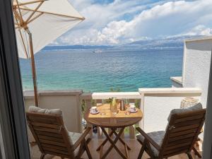 a table and chairs on a balcony with the ocean at Apartment Bistrica Sunce in Sutivan