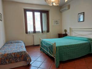 sypialnia z dwoma łóżkami i oknem w obiekcie Casa Vacanze - La Ginestra w mieście Ginestra