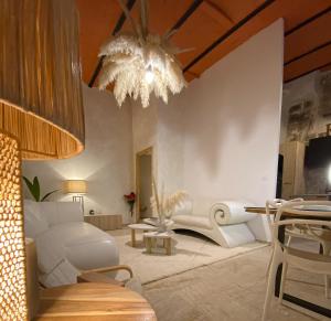 a living room with a white couch and a chandelier at Pamp’Arles in Arles