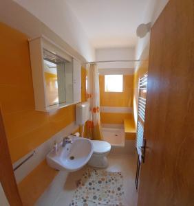 La salle de bains est pourvue de toilettes blanches et d'un lavabo. dans l'établissement Gvačić House, à Supetarska Draga