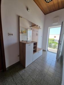 a bathroom with a sink and a counter with a window at Apartments Vuko Seget Vranjica in Seget Vranjica