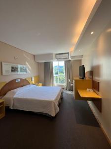um quarto de hotel com uma cama e uma janela em Hotel Aliança Express em Rio do Sul