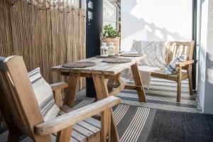 una mesa de madera y 2 sillas en el patio en Apartamenty przy plaży, en Jastarnia