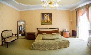 a bedroom with a bed and a chair and a mirror at Hotel Madrid in Odesa