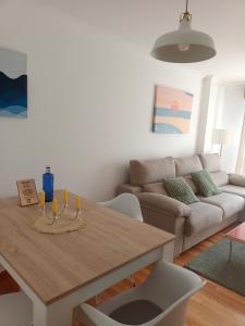 a living room with a table and a couch at Apartamento Mar de Arousa in Ribeira