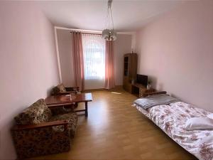 Zimmer mit einem Bett, einem Tisch und einem Sofa in der Unterkunft Pokoje W Pięknej Kamienicy W Centrum W Głogówku in Głogówek